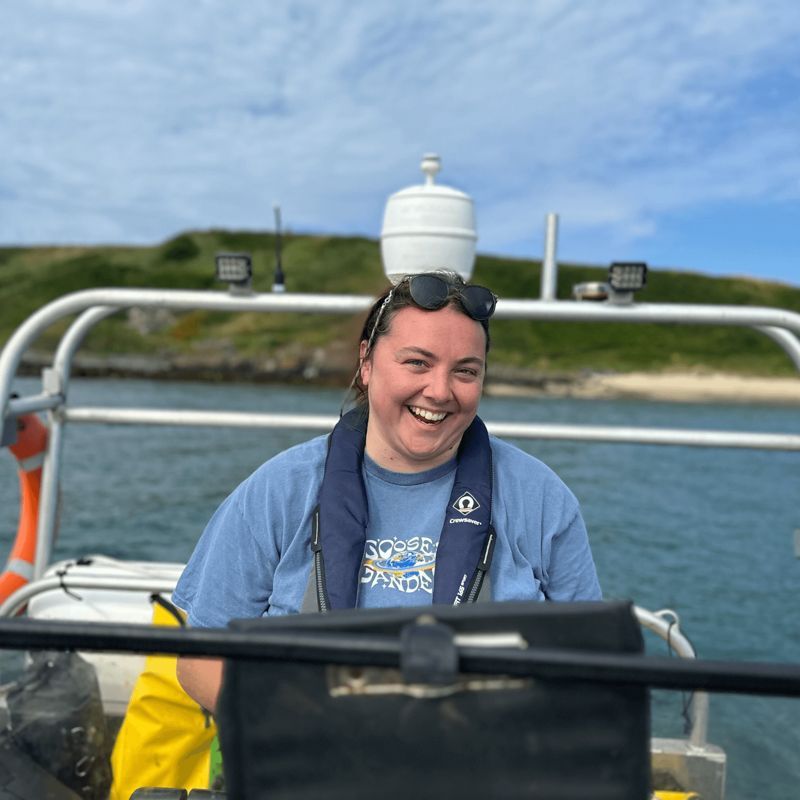 Eve is wearing a blue t-shirt and is standing on Project Seagrass' boat Gwen.