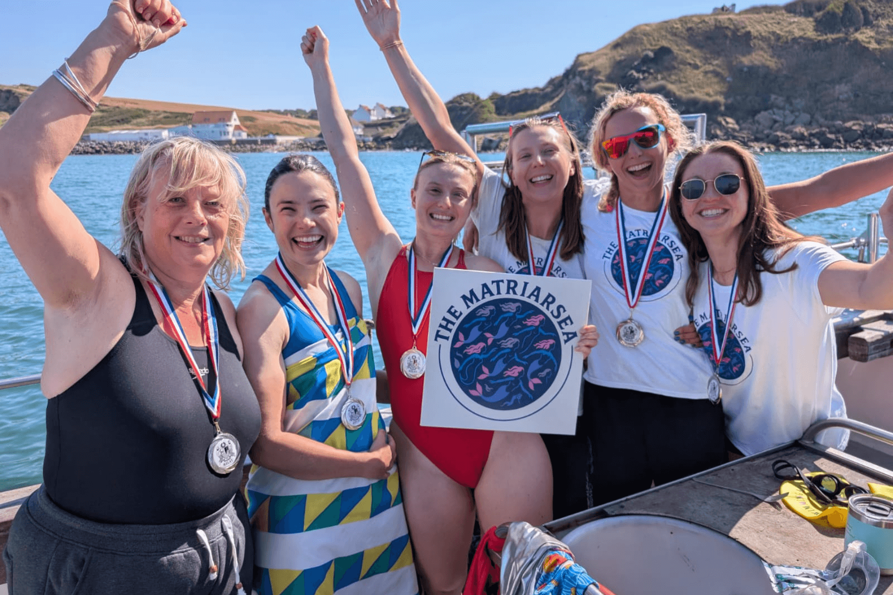 6 team members stand aboard a boat after swimming the Channel