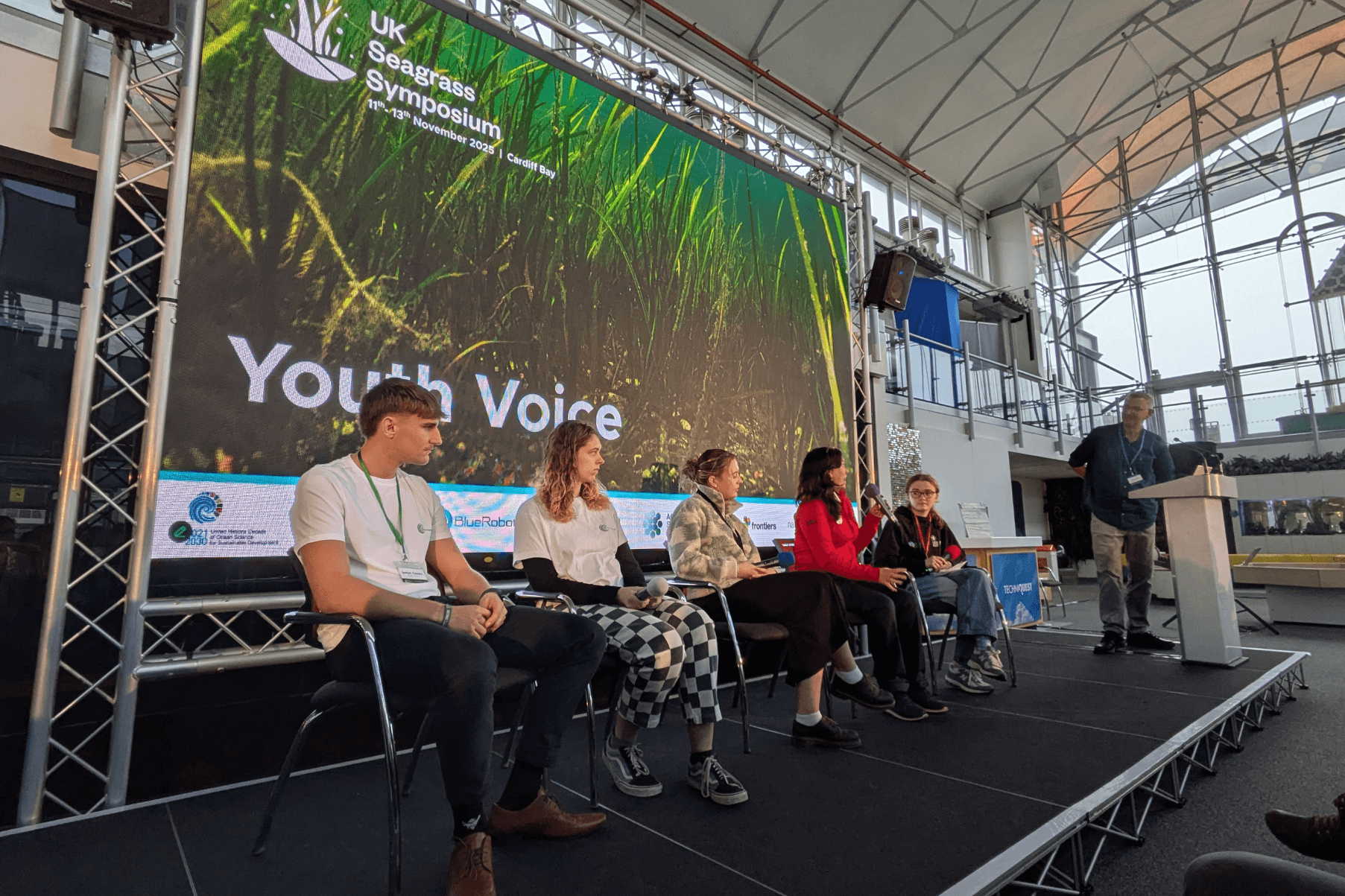 5 young people are seating on the main stage at the UK Seagrass Symposium.