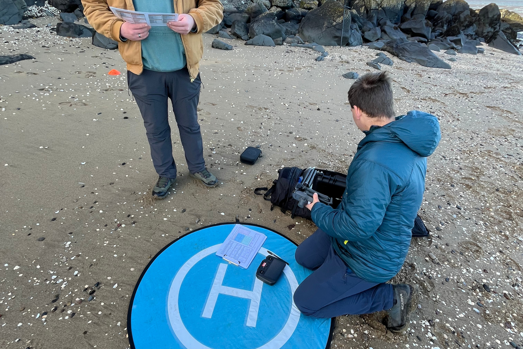 Calum and Jasper on a beach setting drone equipment