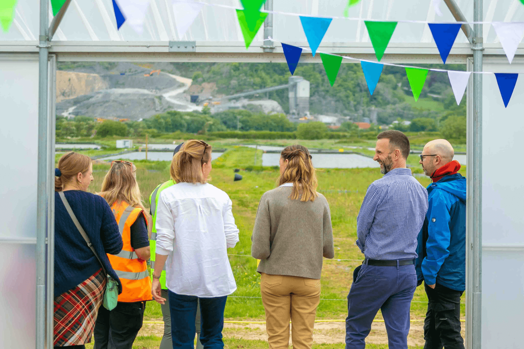 A group of visitors are gathered in the doorway of the polytunnel at the Project Seagrass Nursery.