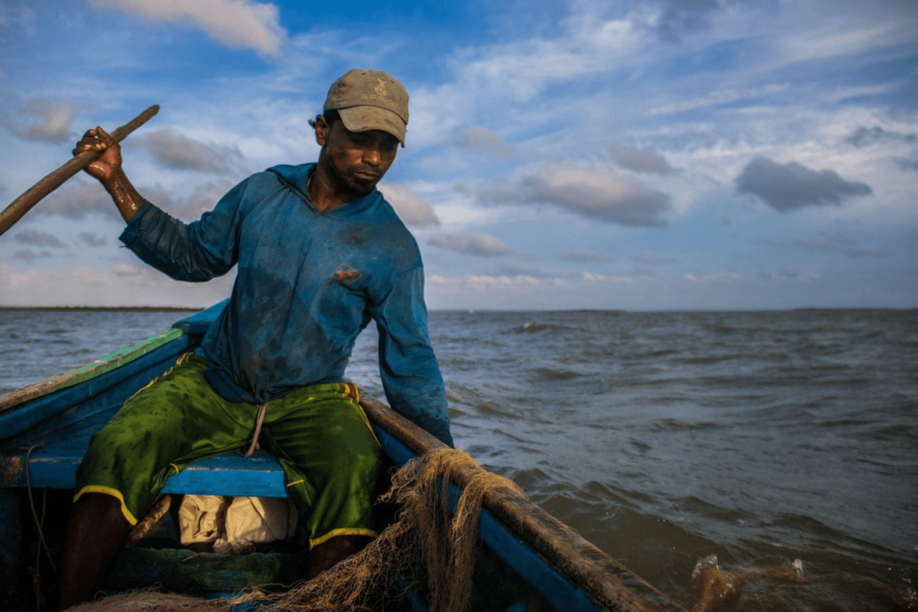 A fisher is out on the water in their vessel
