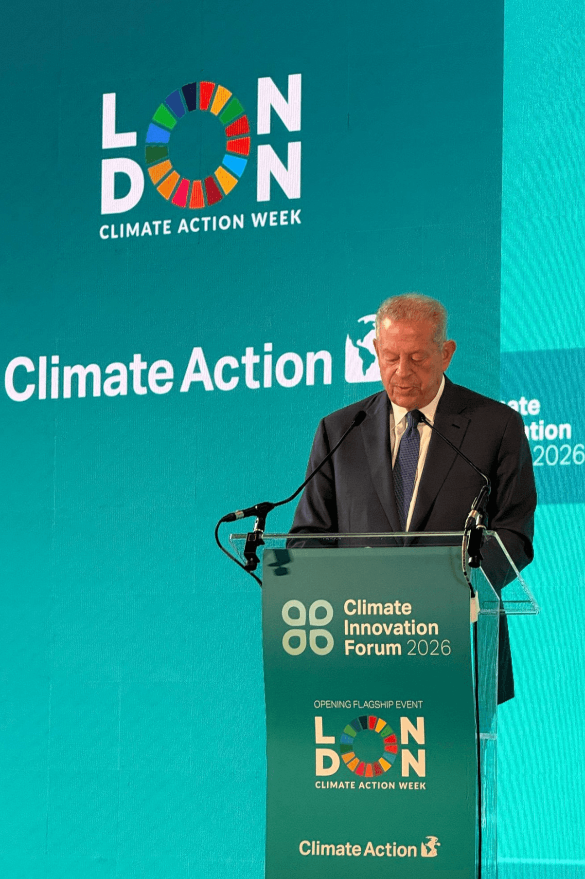 Al Gore stands at a podium delivering a speech at London Climate Action Week.
