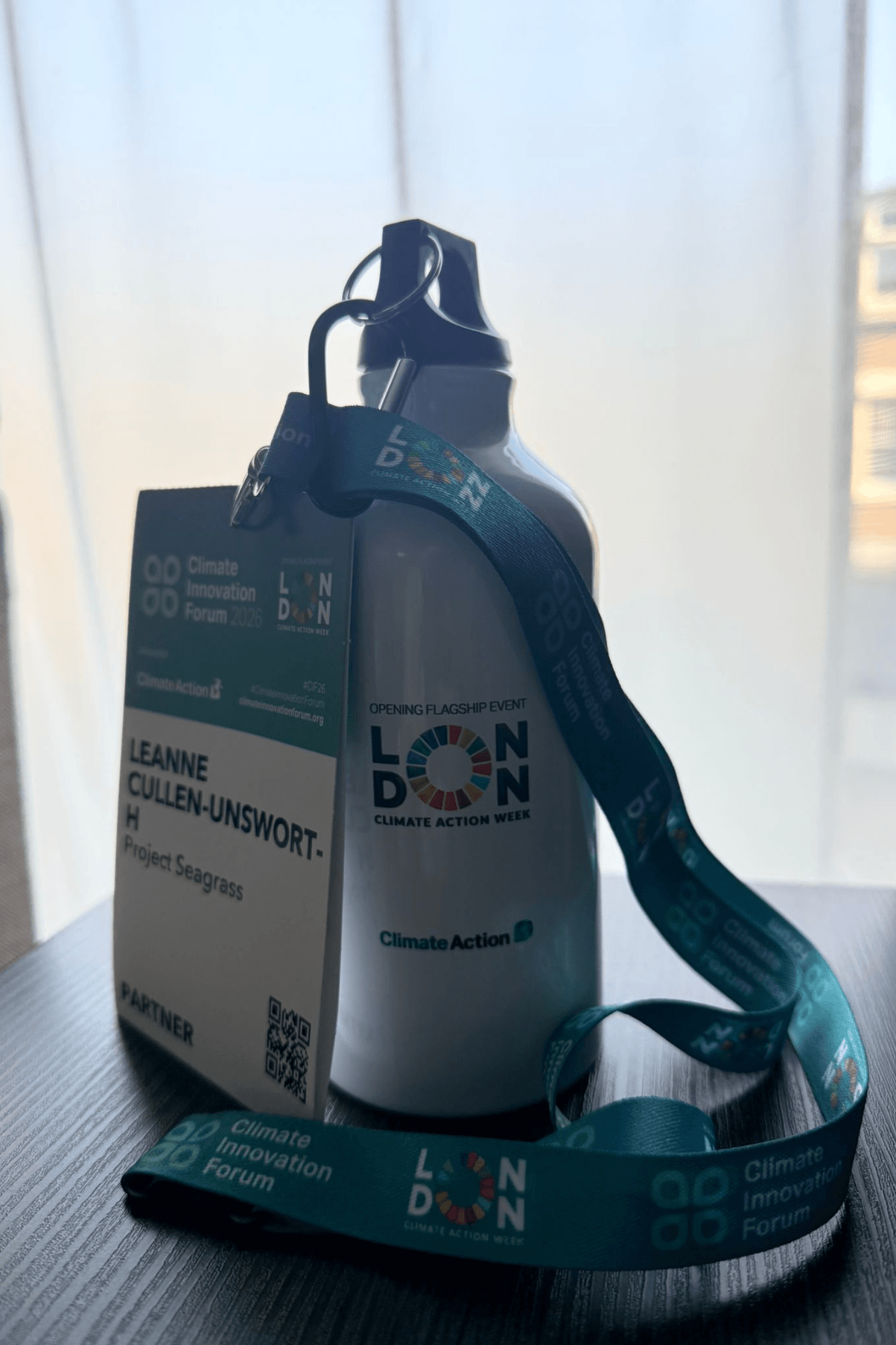 Leanne's delegate lanyard is propped up against a London Climate Action Week water bottle.