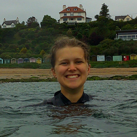Hannah is in the sea wearing a wetsuit.